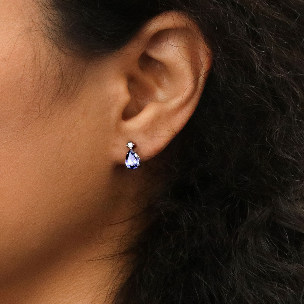 Model wearing Solitaire Pear Cut Set in Sterling Silver, Tanzanite Color