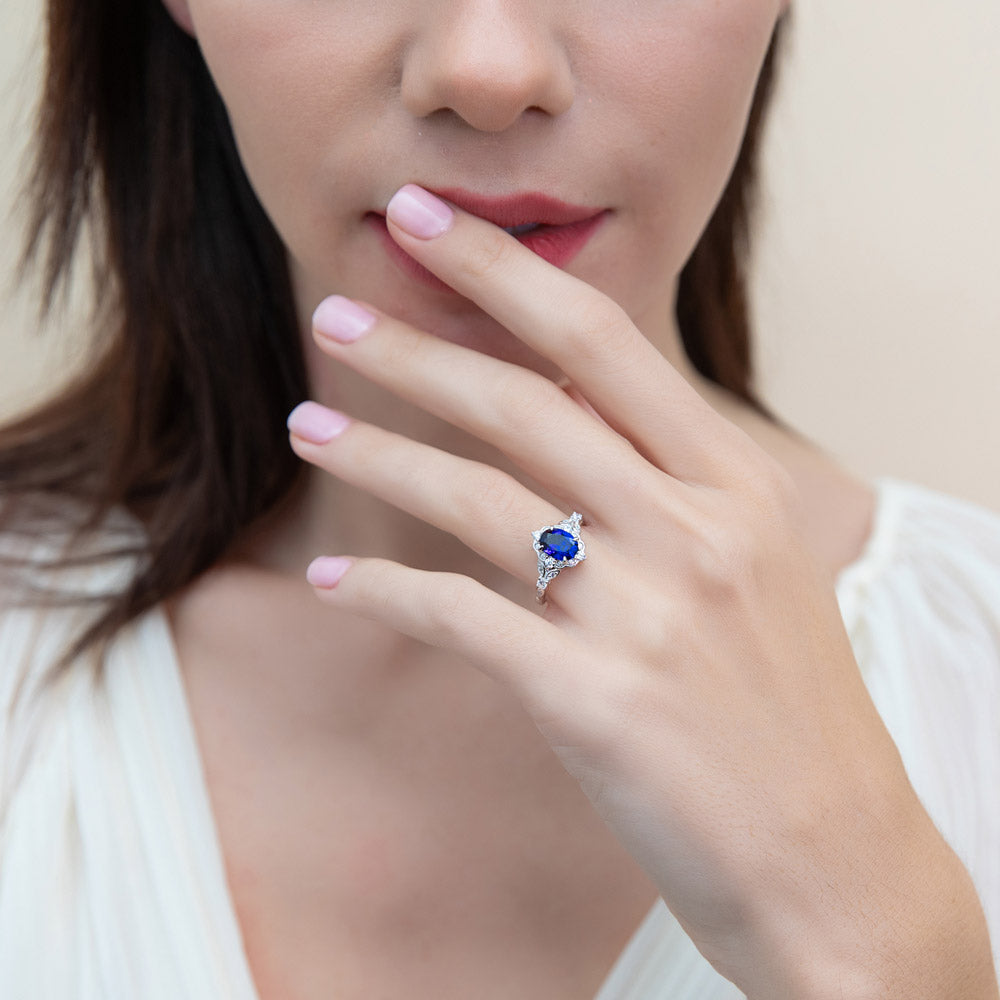 Model wearing Halo Simulated Blue Sapphire Oval CZ Ring Set in Sterling Silver, 11 of 16
