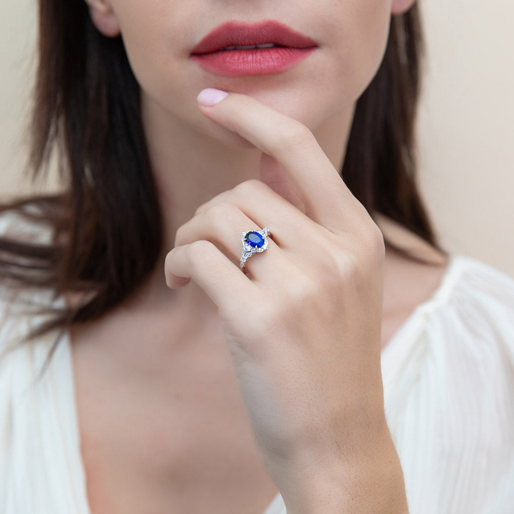 Model wearing Halo Simulated Blue Sapphire Oval CZ Ring Set in Sterling Silver, 10 of 16