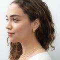 Model wearing Dome CZ Small Huggie Earrings in Sterling Silver 0.6 inch, Yellow Gold Flashed, Cubic Zirconia