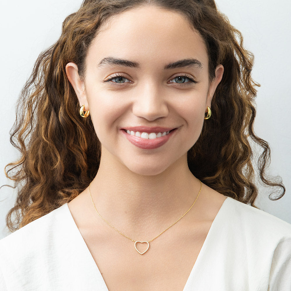 Model wearing Oval Dome Small Huggie Earrings in Sterling Silver 0.6 inch, Yellow Gold Flashed