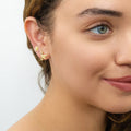 Model wearing Hummingbird Flower CZ Stud Earrings in Sterling Silver, Gold Flashed