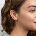 Model wearing Cartilage Graduated CZ Cartilage Stud Earrings in Sterling Silver, Yellow Gold Flashed