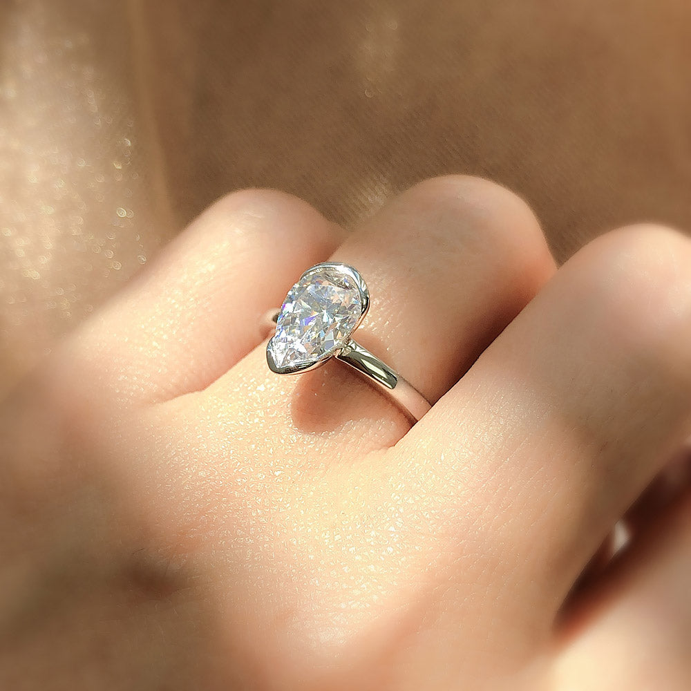 Model wearing Solitaire 1.8ct Bezel Pear CZ Ring Set in Sterling Silver, 3 of 9