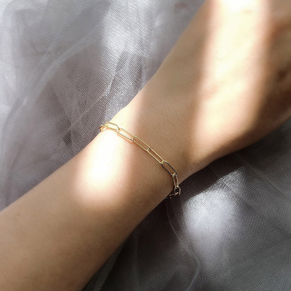 Model wearing Paperclip Link Chain Bracelet in Sterling Silver 4mm, Yellow Gold Flashed