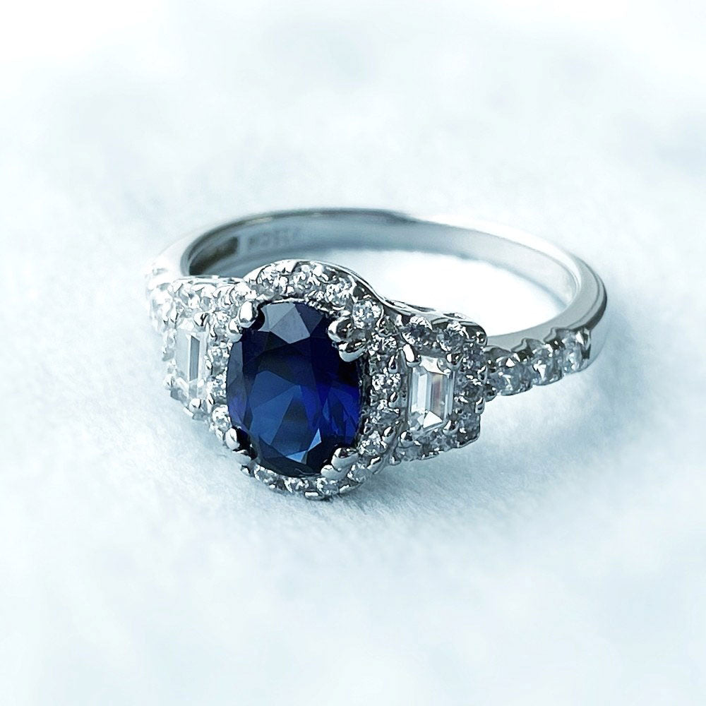 Flatlay view of 3-Stone Halo Art Deco Sapphire-Blue CZ Ring in Sterling Silver, 9 of 9