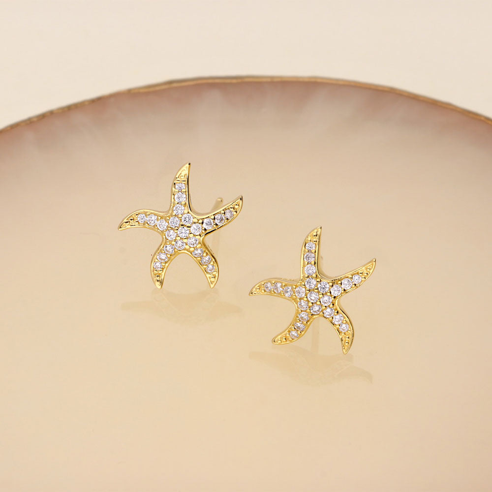 Flatlay view of Starfish CZ Stud Earrings in Sterling Silver, Yellow Gold Flashed