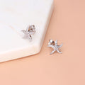 Flatlay view of Starfish CZ Stud Earrings in Sterling Silver, Yellow Gold Flashed