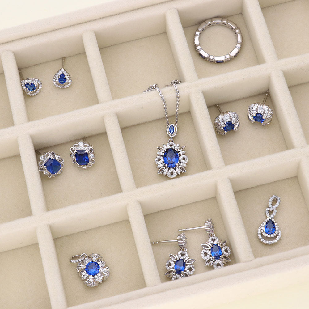 Flatlay view of Flower Halo Simulated Blue Sapphire CZ Earrings in Sterling Silver, 6 of 6