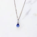 Flatlay view of Solitaire Pear Necklace in Sterling Silver 1ct, Tanzanite Color