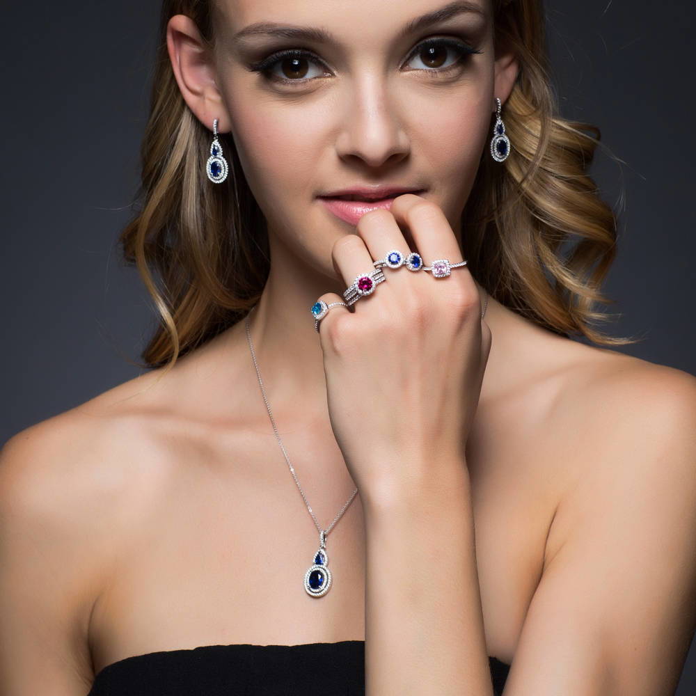 Model wearing Halo Sapphire-Blue Oval CZ Earrings in Sterling Silver, 2 of 2