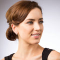 Model wearing Fleur De Lis CZ Small Huggie Earrings in Sterling Silver 0.5 inch, Yellow Gold Flashed