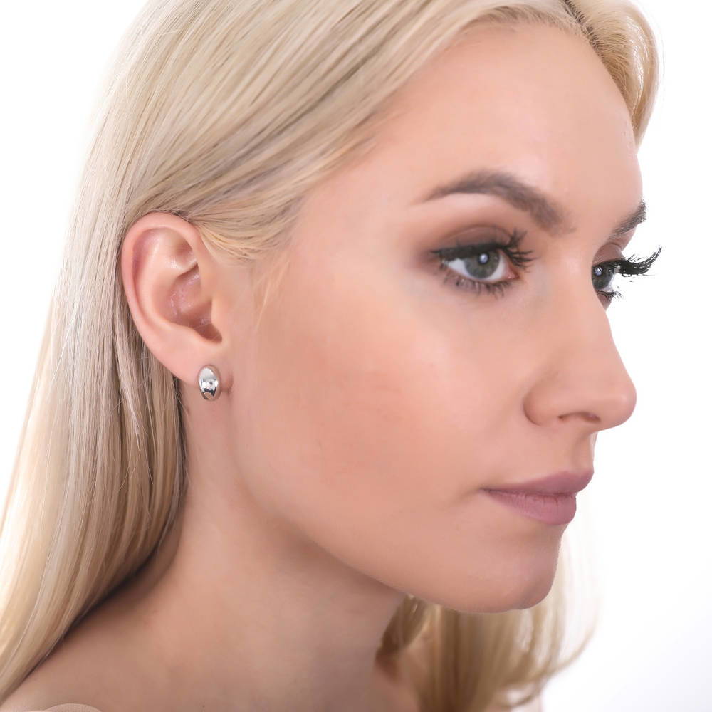 Model wearing Dome Mini Huggie Earrings in Sterling Silver 0.5 inch, Rhodium Plated