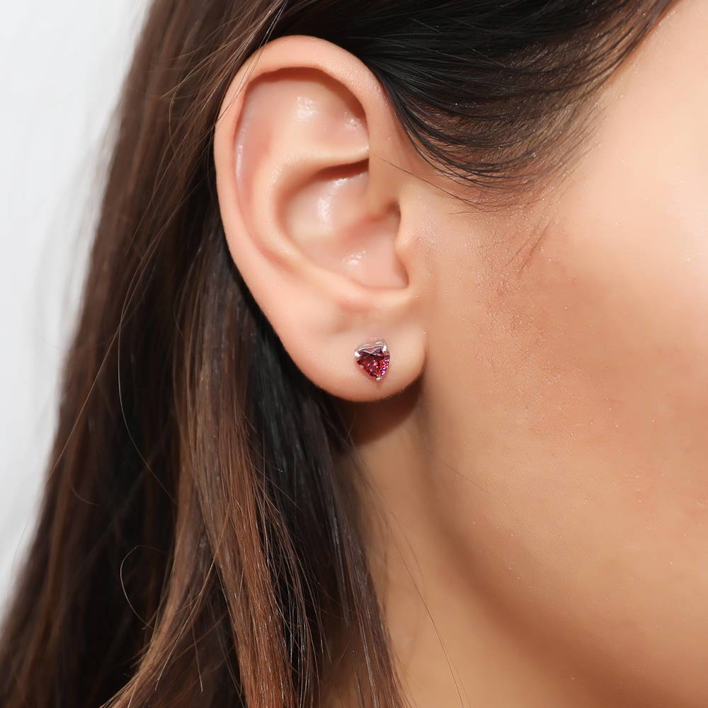 Model wearing Solitaire Heart Red Heart CZ Stud Earrings in Sterling Silver, 2 of 4