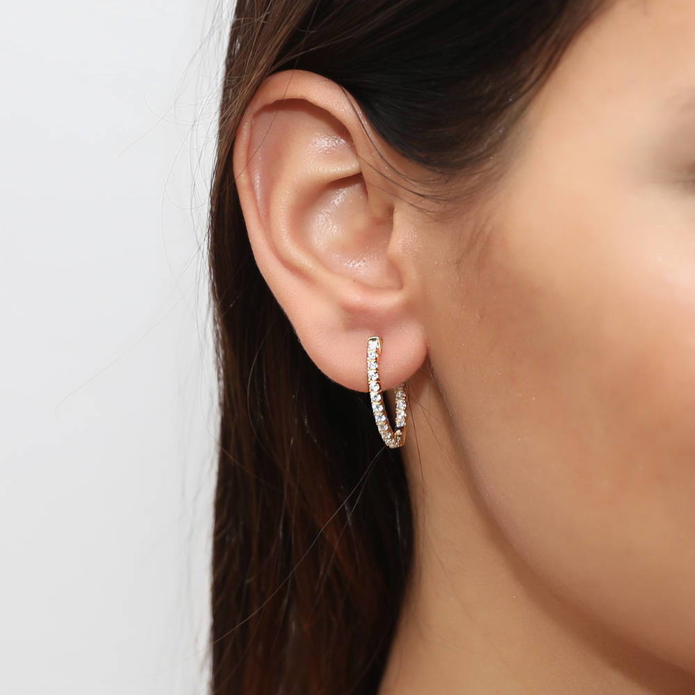 Model wearing Oval CZ Small Inside-Out Hoop Earrings in Sterling Silver 0.8 inch, Yellow Gold Flashed
