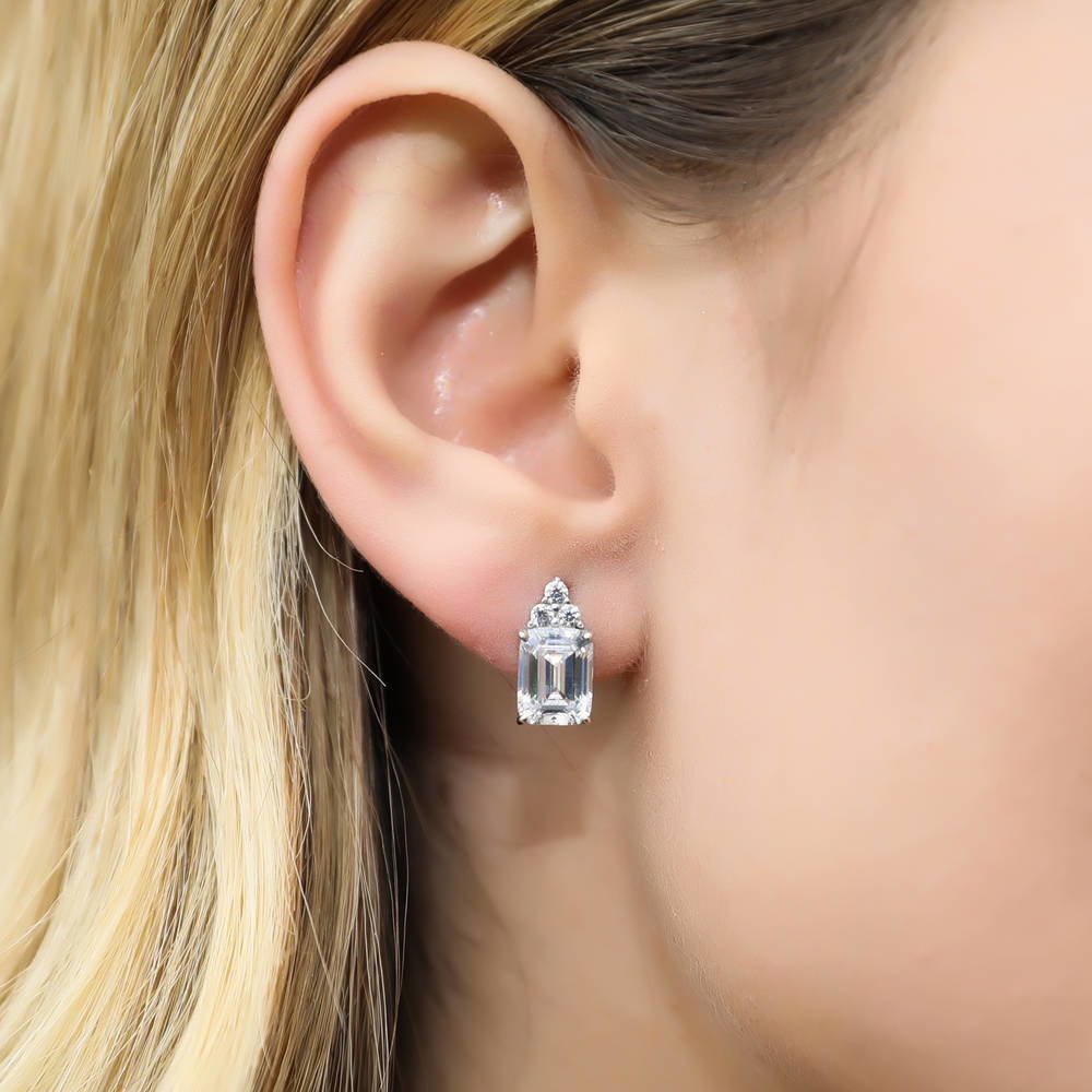 Model wearing Solitaire 4.2ct Emerald Cut CZ Stud Earrings in Sterling Silver, 5 of 7
