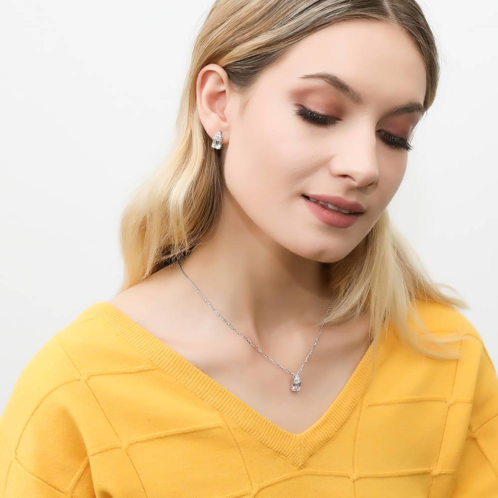 Model wearing Solitaire 4.2ct Emerald Cut CZ Stud Earrings in Sterling Silver, 7 of 7