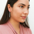 Model wearing CZ Large Inside-Out Hoop Earrings in Sterling Silver 2 inch, Rhodium Plated