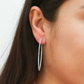 Model wearing CZ Large Inside-Out Hoop Earrings in Sterling Silver 2 inch, Rhodium Plated