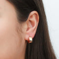 Model wearing Small Huggie Earrings in Sterling Silver 0.55 inch, Yellow Gold Flashed