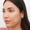 Model wearing Clover CZ Small Huggie Earrings in Sterling Silver 0.55 inch, Yellow Gold Flashed