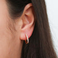 Model wearing Oval Bar CZ Medium Hoop Earrings in Sterling Silver 0.6 inch, Yellow Gold Flashed