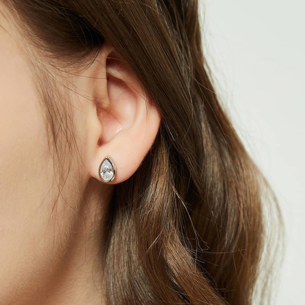 Model wearing Solitaire 1.6ct Bezel Pear CZ Stud Earrings in Sterling Silver, 3 of 6