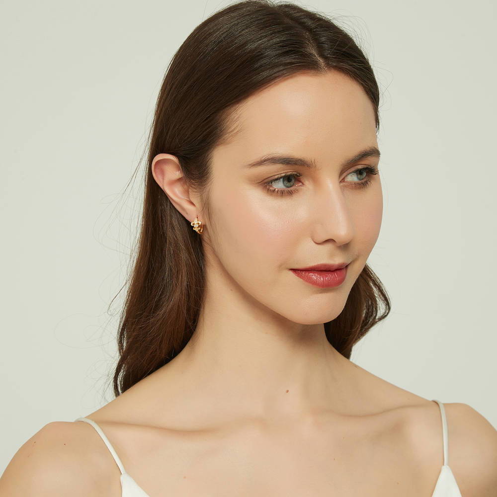 Model wearing Fleur De Lis CZ Mini Huggie Earrings in Sterling Silver 0.5 inch, Rhodium Plated