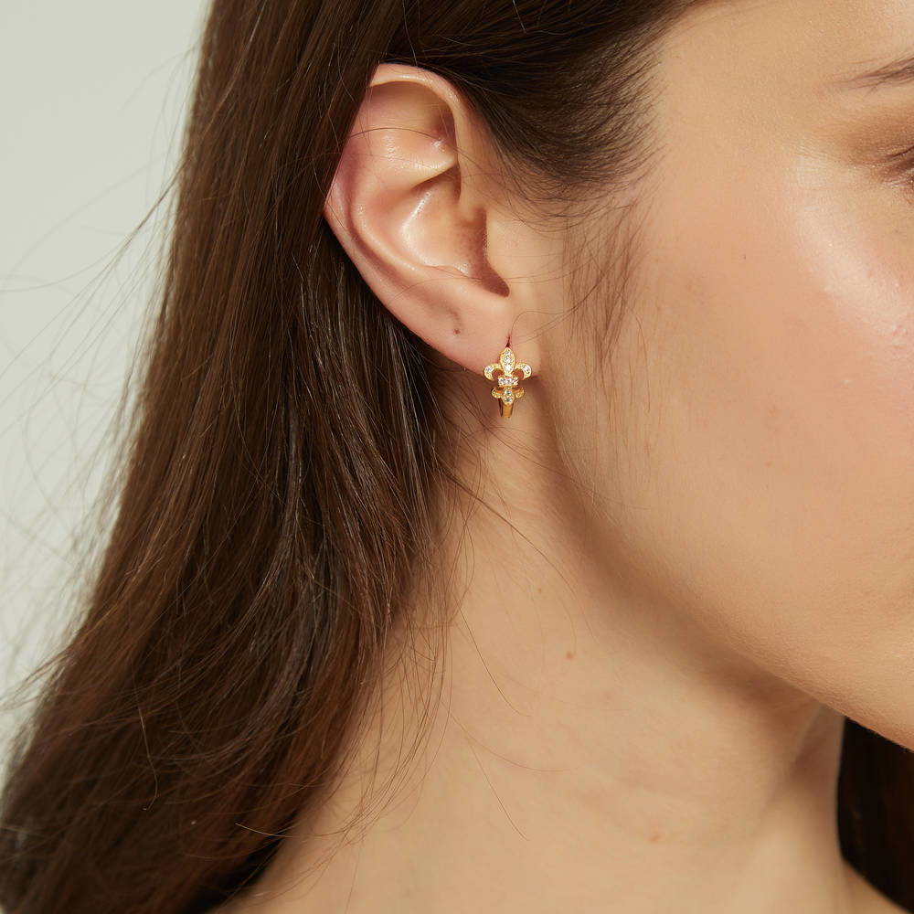 Model wearing Fleur De Lis CZ Mini Huggie Earrings in Sterling Silver 0.5 inch, Rhodium Plated