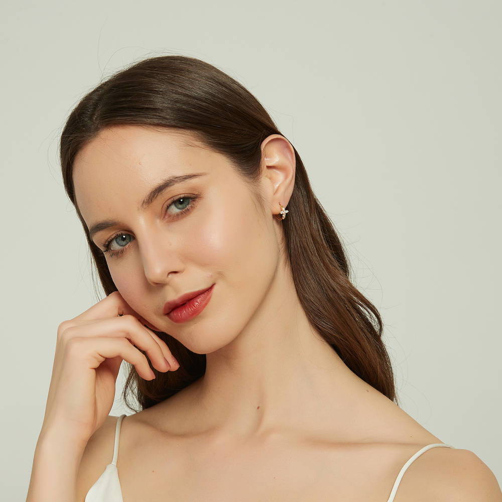 Model wearing Cross CZ Mini Huggie Earrings in Sterling Silver 0.5 inch, Yellow Gold Flashed
