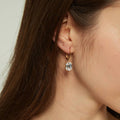 Model wearing Solitaire Emerald Cut CZ Leverback Earrings in Sterling Silver, Yellow Gold Flashed