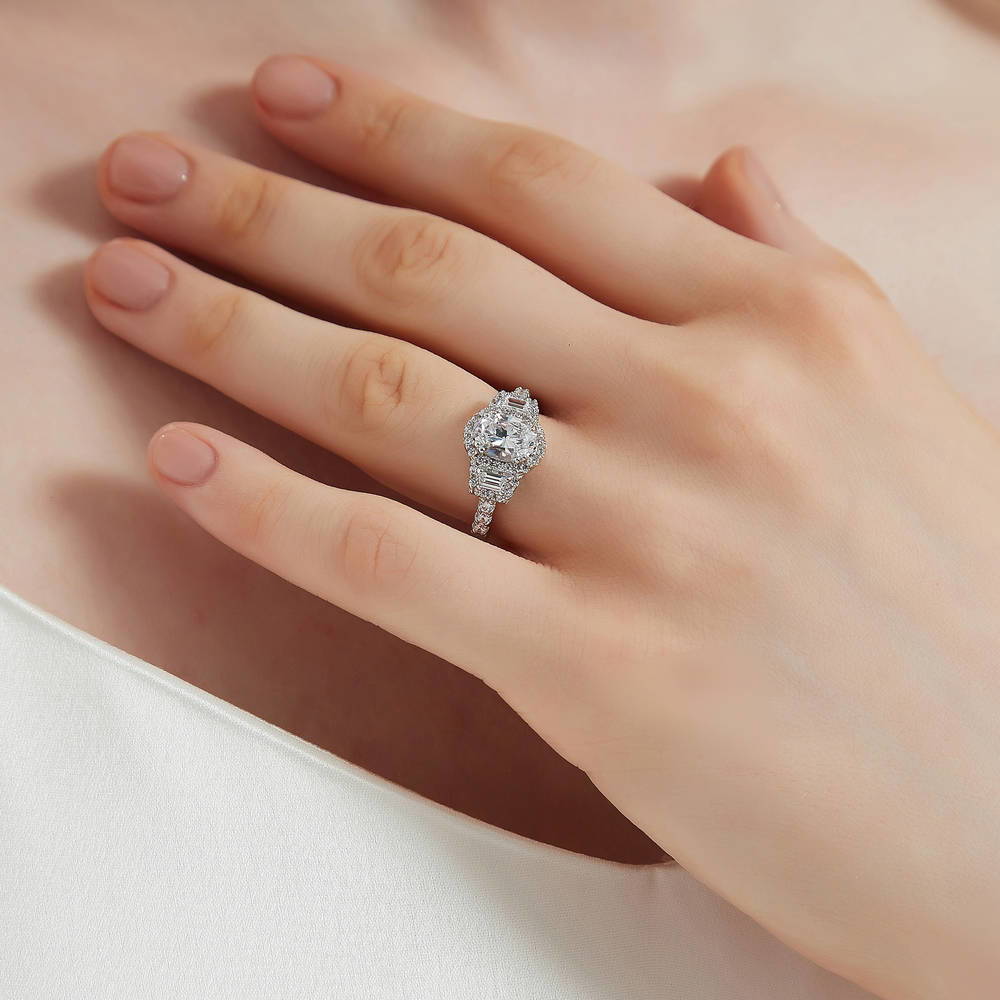 Model wearing 3-Stone Halo Art Deco 1.2ct Oval CZ Ring in Sterling Silver, 3 of 10