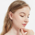 Model wearing Solitaire Pear CZ Leverback Earrings in Sterling Silver, Red Color