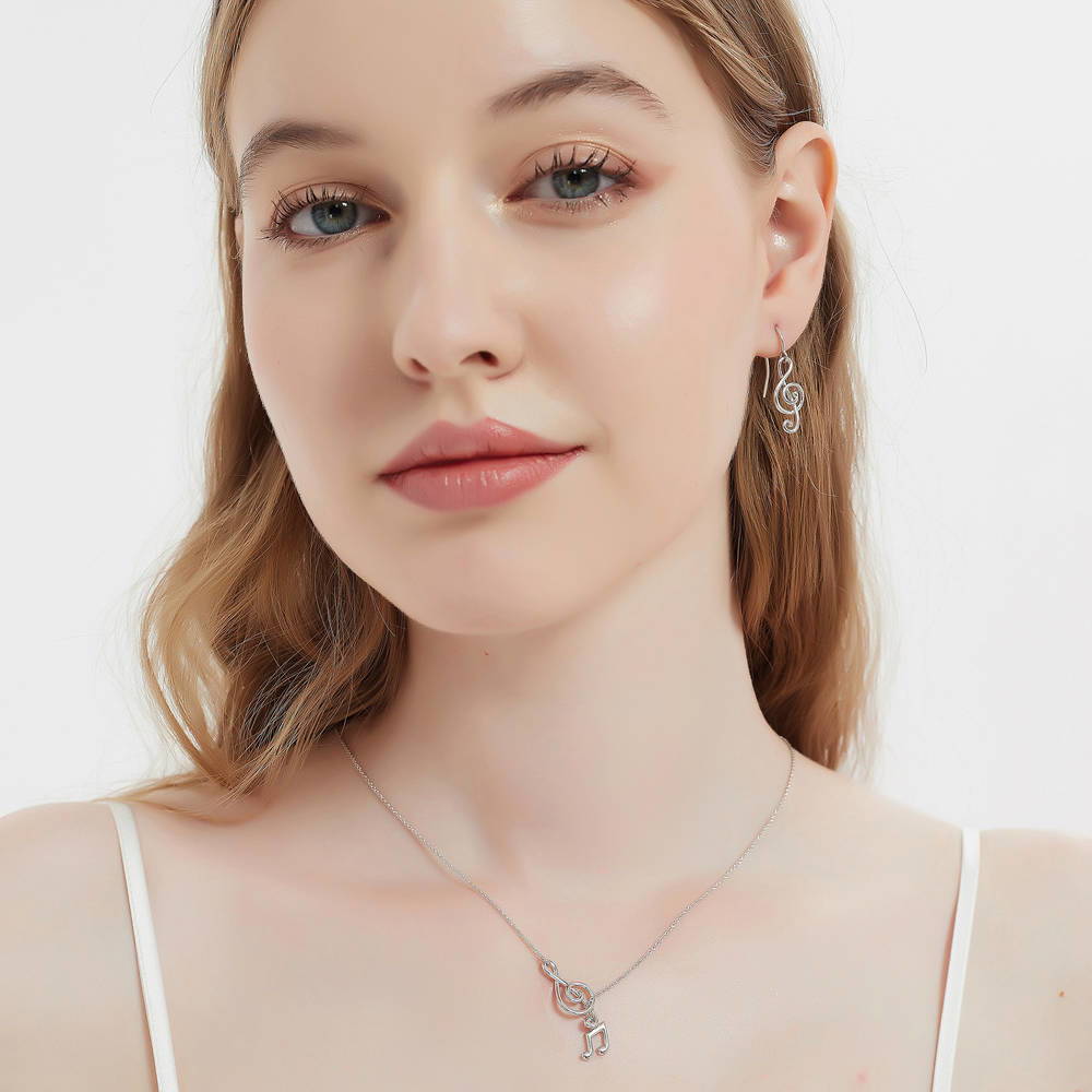 Model wearing Treble Clef Music Note Fish Hook Earrings in Sterling Silver, 6 of 7