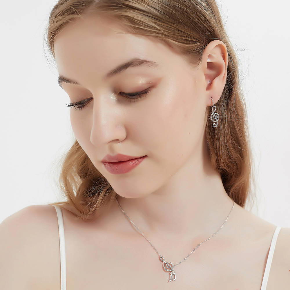 Model wearing Treble Clef Music Note Fish Hook Earrings in Sterling Silver, 5 of 7