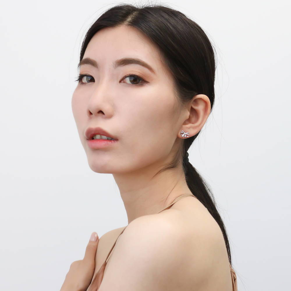 Model wearing Bow Tie Ribbon CZ Stud Earrings in Sterling Silver, Style 1