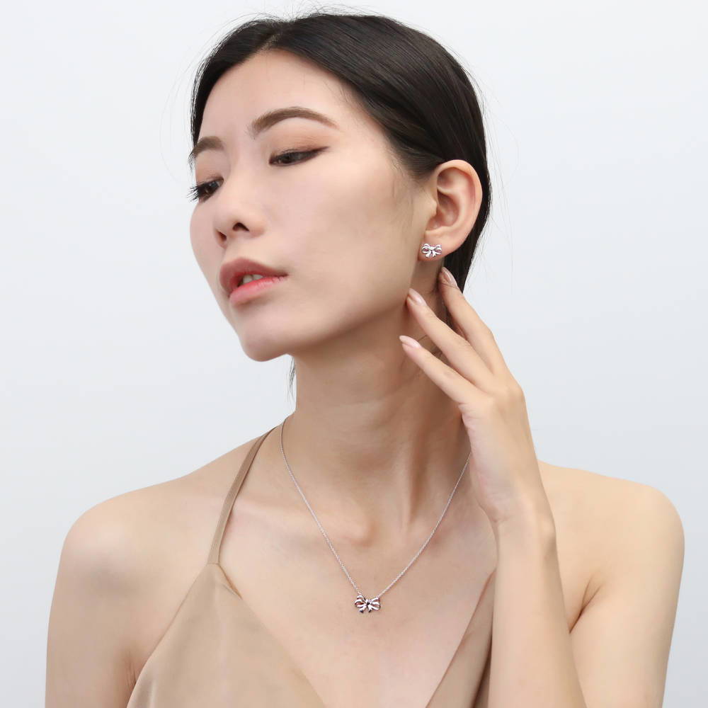 Model wearing Bow Tie Ribbon CZ Stud Earrings in Sterling Silver, Style 1