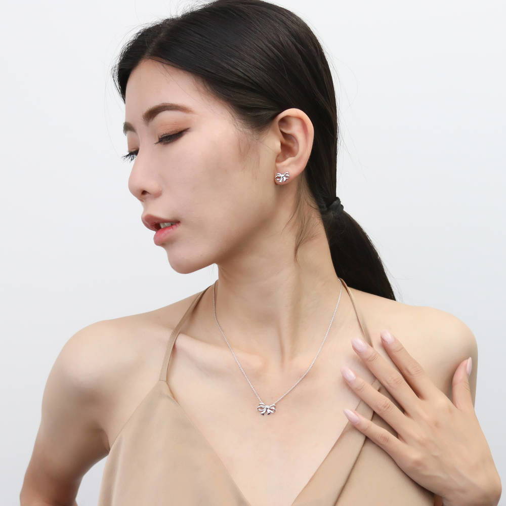 Model wearing Bow Tie Ribbon CZ Stud Earrings in Sterling Silver, Style 1