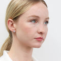 Model wearing Halo CZ Stud Earrings in Sterling Silver, Rose Gold Flashed