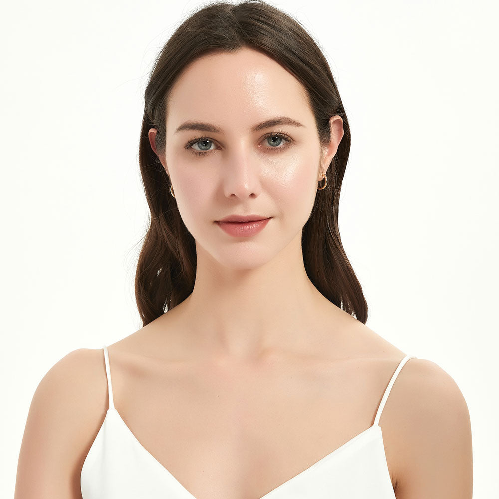 Model wearing Small Hoop Earrings in Sterling Silver 0.6 inch, Yellow Gold Flashed