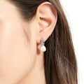 Model wearing Solitaire Cultured Pearl Stud Earrings in Sterling Silver, Yellow Gold Flashed