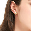 Model wearing Solitaire Clam Cultured Pearl Stud Earrings in Sterling Silver, Yellow Gold Flashed