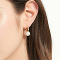 Model wearing Solitaire Cultured Pearl Stud Earrings in Sterling Silver, Yellow Gold Flashed