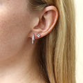 Model wearing Solitaire Princess CZ Stud Earrings in Sterling Silver, 4mm