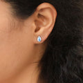 Model wearing Halo Pear CZ Stud Earrings in Sterling Silver, Greyish Blue Color