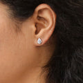 Model wearing Halo Pear CZ Stud Earrings in Sterling Silver, Clear Color