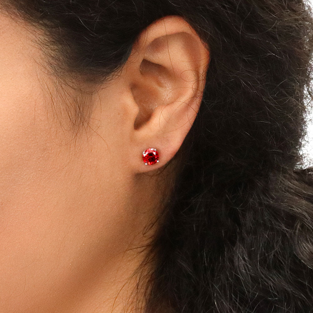 Model wearing Solitaire 1.6ct CZ Cartilage Stud Earrings in Sterling Silver, Garnet Color